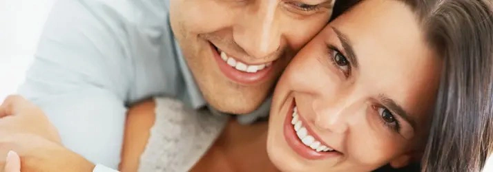 Close-up of two people smiling with faces together